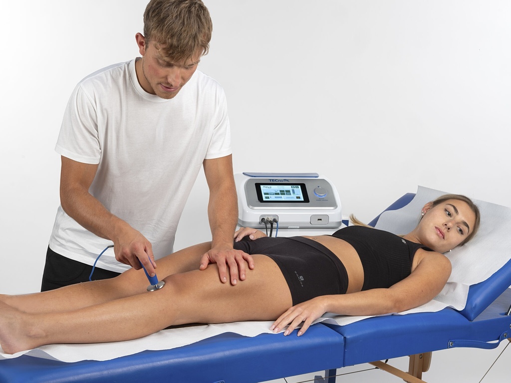 Aplicación del electrodo de la Tecnosix CR5 sobre el gemelo, con la mano del fisioterapeuta guiando la zona