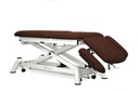 Camilla eléctrica para osteopatía de 5 secciones con respaldo reclinable en negativo, pliegue central y subida recta sin desplazamiento lateral. Incluye reposabrazos a la altura del respaldo regulables en altura y anchura, tapón facial y ruedas escamoteables. Con posición de Trendelenburg mediante dos pistones de gas. MBC